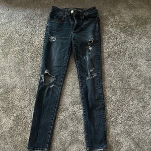 American Eagle dark wash skinny jeans with rips.